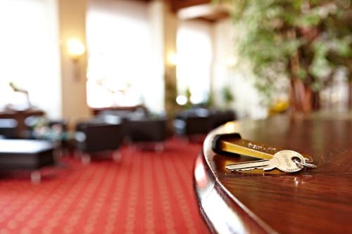 a pair of keys sitting on a wooden table at Hotel Vier Jahreszeiten in Garmisch-Partenkirchen