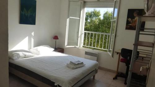 una camera da letto con un letto e una finestra di Appartement moderne à Montpellier, 45 m², climatisation a Montpellier