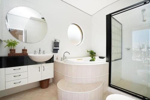 a white bathroom with a sink and a mirror at Villa Utopia On The Marina 3 Bed, 3 Bath in Stuart Park