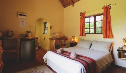 a bedroom with a bed and a window at Away with the Fairies Nature Lodge and Backpackers in Hogsback