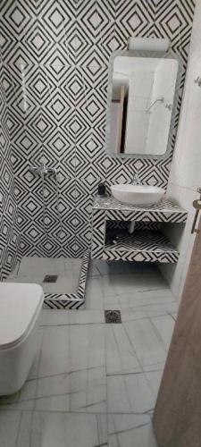 a bathroom with a black and white patterned wall at 3 Goddesses' studios in Koukounaries