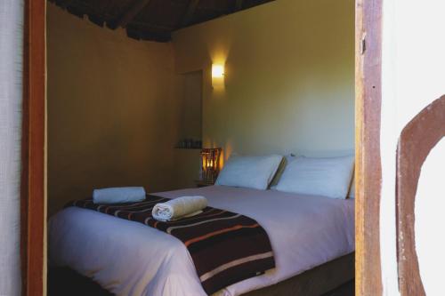 a bedroom with two beds with white sheets at Away with the Fairies Nature Lodge and Backpackers in Hogsback