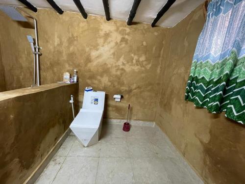 Baño con aseo en la esquina de una habitación en Paje Village House, en Paje