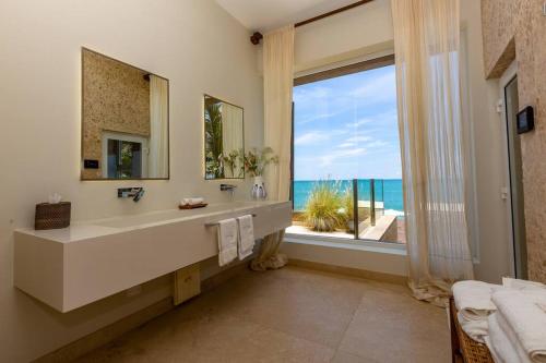 une salle de bain avec un lavabo et une grande fenêtre dans l'établissement Espectacular Villa en Pocitas, à Puerto Máncora