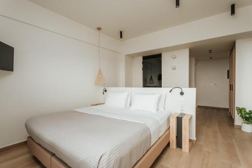 a bedroom with a white bed with white sheets at Paralos The Maxine Adults Only in Agia Galini