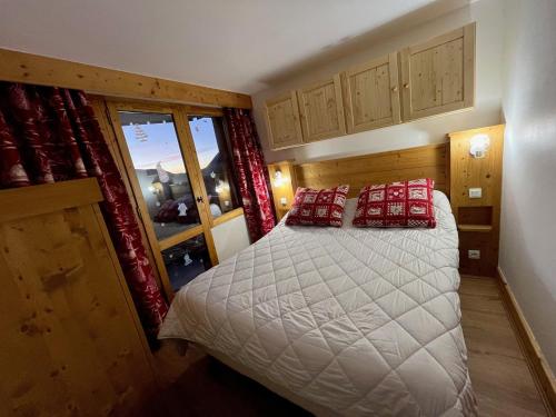 - une chambre avec un lit doté d'oreillers rouges dans l'établissement Appartement chaleureux 7 pers · Accès direct aux pistes · Casier à skis · 2 salles de bain - FR-1-181-2020, à La Plagne Tarentaise