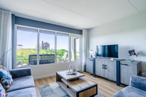 a living room with a couch and a tv at Appartementencomplex Juliana 42 in De Koog
