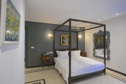 a bedroom with a canopy bed with a mirror at L'Hôtel Particulier La Marsa in La Marsa