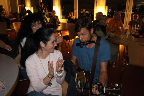 a group of people sitting in a restaurant playing guitar at Jugendherberge Stuttgart International in Stuttgart