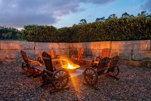 a group of chairs sitting around a fire pit at Luxury Hunter Valley Acreage - Heated SwimSpa - Mountain Views - Pool Table - Fire Pitt in Millfield