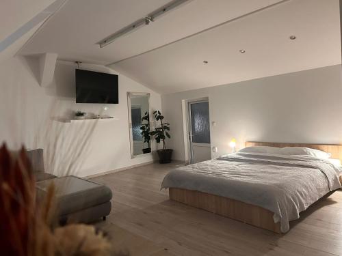 a white bedroom with a bed and a couch at Grand BBQ in Sibiu