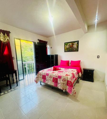 a bedroom with a large bed with pink pillows at Hotel Luna in San Marcos La Laguna