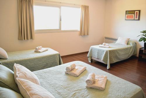 a room with two beds with towels on the floor at Alamo Hotel in Villa Carlos Paz