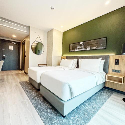 a bedroom with a large bed and a green wall at Park Inn by Radisson Yalova City Center in Yalova