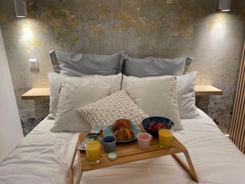 - un plateau de nourriture sur un lit avec deux verres de jus d'orange dans l'établissement Saint-Remy, à Troyes