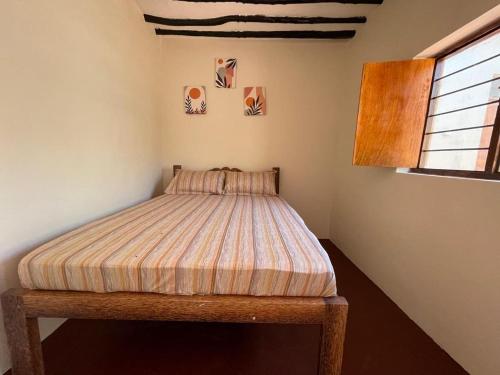 1 cama en la esquina de un dormitorio en Paje Village House, en Paje