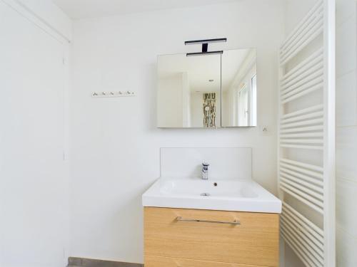 une salle de bain avec un lavabo et un miroir dans l'établissement À 15min à pied de la plage, maison pour 6, à Les Sables-dʼOlonne