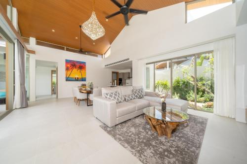 a living room with a couch and a table at Villa private swimming pool and garden in Phuket Town
