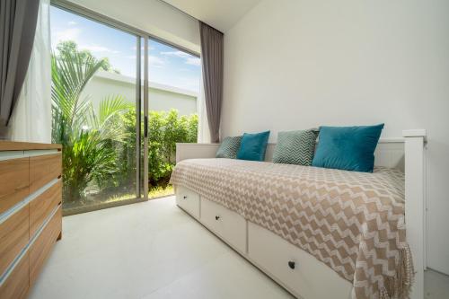 a bedroom with a bed and a large window at Villa private swimming pool and garden in Phuket Town