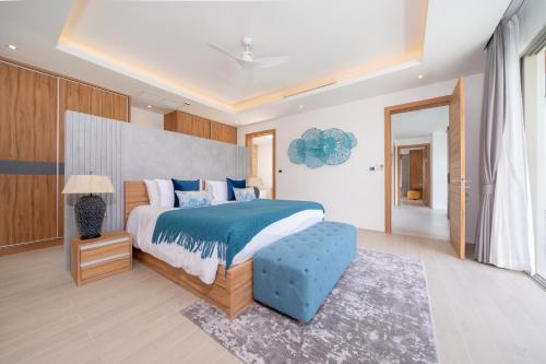 a bedroom with a large bed and a blue ottoman at Villa private swimming pool and garden in Phuket Town