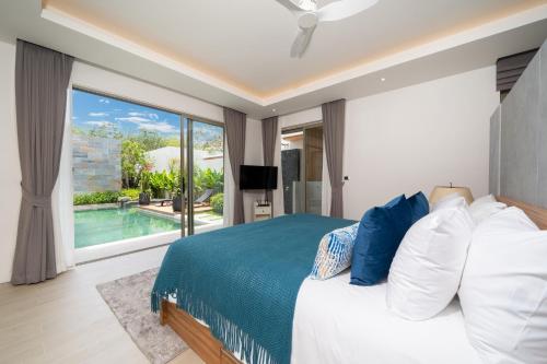 a bedroom with a bed and a view of a pool at Villa private swimming pool and garden in Phuket Town