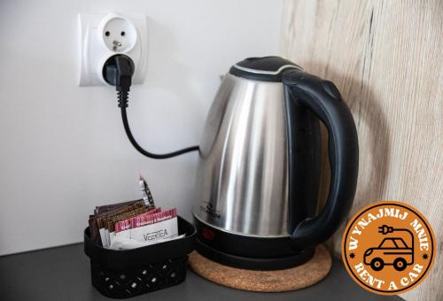 a tea kettle on a counter next to a telephone at ADLER CHILL Apartments in Łódź