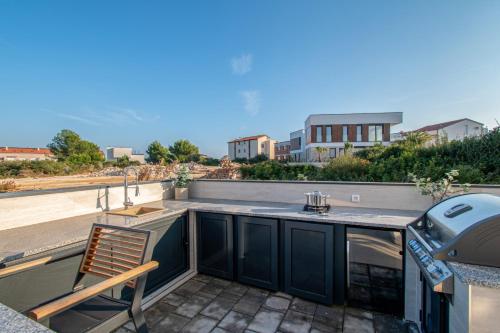 a patio with a table and a chair on a roof at Villa Ajlin mit privatem beheizbarem Pool in Medulin