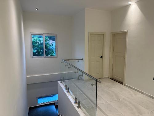 a white room with a glass staircase and a window at Hotel Boutique Las Mesetas in San Pedro Sula