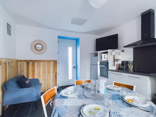 une salle à manger avec une table et une cuisine dans l'établissement St Hilaire de Riez, Maison de ville pour 6, à Saint-Hilaire-de-Riez