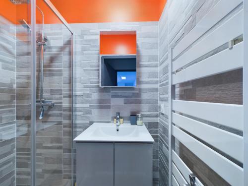 a bathroom with a sink and a tv at St Hilaire de Riez, Maison de ville pour 6 in Saint-Hilaire-de-Riez