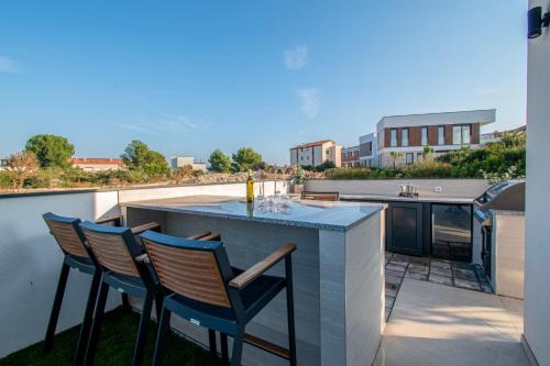 a patio with a table and chairs on a balcony at Villa Ajlin mit privatem beheizbarem Pool in Medulin