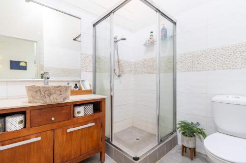 a bathroom with a shower and a toilet and a sink at Tropical Garden Villa 5 Mins From City Centre in Paraparap
