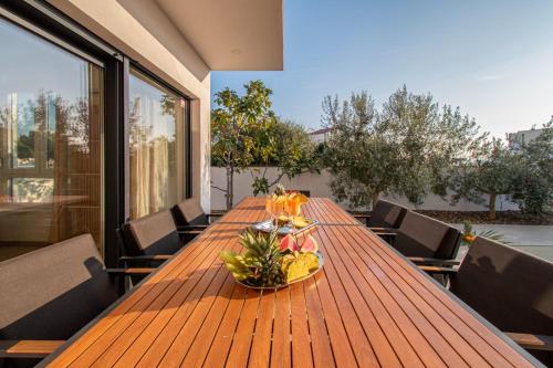 a wooden table with a bowl of fruit on a balcony at Villa Ajlin mit privatem beheizbarem Pool in Medulin