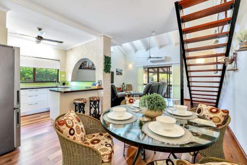 a kitchen and living room with a table and chairs at Tranquil Townhouse Huge Pool & Golf Course Views in Casuarina