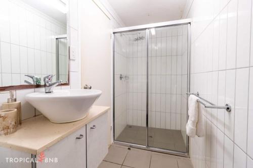 a white bathroom with a sink and a shower at Marina Magic 2 Bed, 2 Bath Apt Stunning Views in Larrakeyah