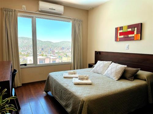 a bedroom with a bed with two towels on it at Alamo Hotel in Villa Carlos Paz