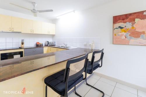 a kitchen with a counter and chairs in a room at Marina Views Cozy 3br Villa In Tipperary Waters in Stuart Park