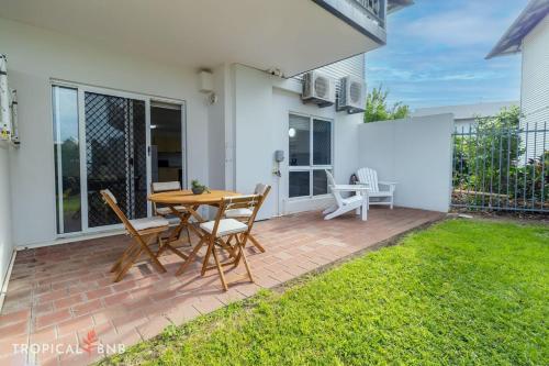 a patio with a table and chairs in a yard at Marina Views Cozy 3br Villa In Tipperary Waters in Stuart Park
