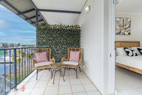 a patio with two chairs and a table on a balcony at Marina Views Cozy 3br Villa In Tipperary Waters in Stuart Park