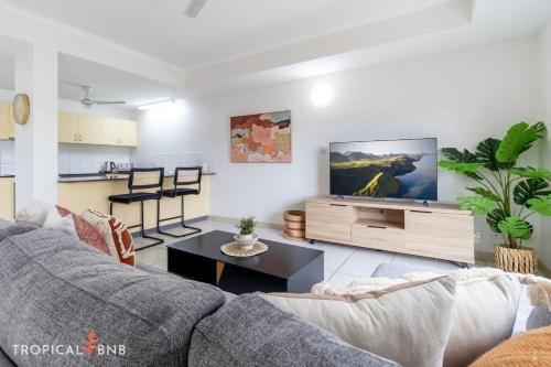 a living room with a couch and a tv at Marina Views Cozy 3br Villa In Tipperary Waters in Stuart Park