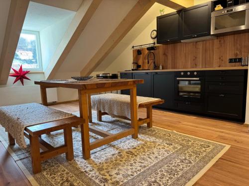 a kitchen with a wooden table and a dining room at Apartmány za Královskou mincovnou in Jáchymov