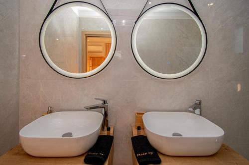a bathroom with two sinks and two mirrors at Villa Ajlin mit privatem beheizbarem Pool in Medulin