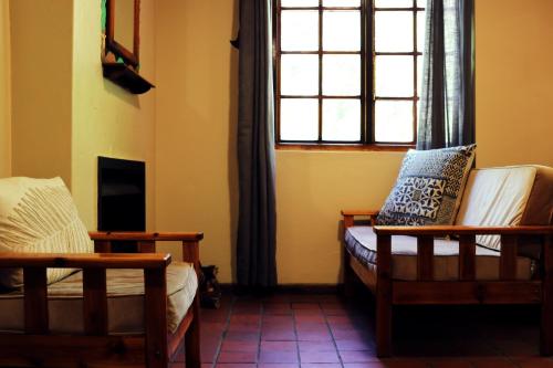 a living room with two chairs and a window at Away with the Fairies Nature Lodge and Backpackers in Hogsback