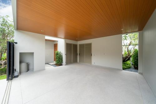 an empty living room with a wooden ceiling at Villa private swimming pool and garden in Phuket Town