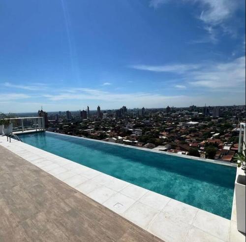 a swimming pool on top of a building with a city at Apartamento con pileta en Asunción centro in Asuncion