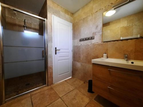La salle de bains est pourvue d'une douche, d'un lavabo et d'une porte. dans l'établissement Aillan Hervé Maison indépendante avec piscine, à Saint-Maurice-sur-Eygues