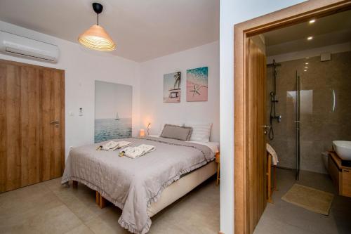 a bedroom with a bed and a bathroom with a shower at Villa Ajlin mit privatem beheizbarem Pool in Medulin