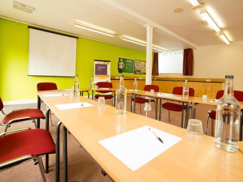 a classroom with tables and chairs and a whiteboard at YHA Ironbridge Coalport in Coalport