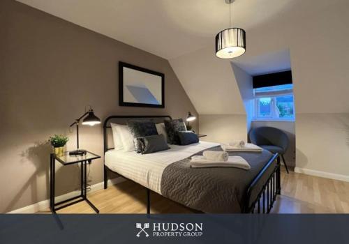 a bedroom with a bed and a chair in it at Telford Townhouse with Parking and Garden in Telford