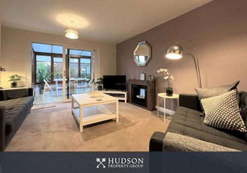 a living room with a couch and a table at Telford Townhouse with Parking and Garden in Telford